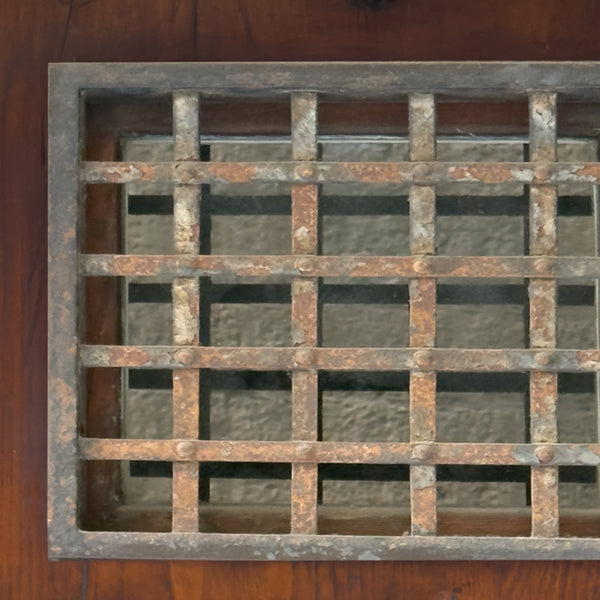 Rust-colored metal grille on a wooden background