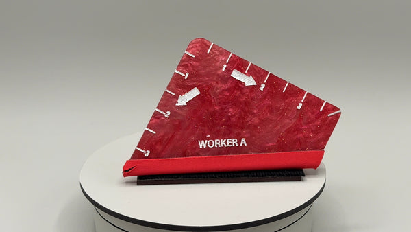 Red shoe with 'WORKER A' branding on a white platform against a gray background