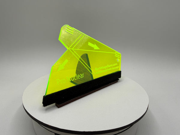 Green squeegee on a white stand with a gray background