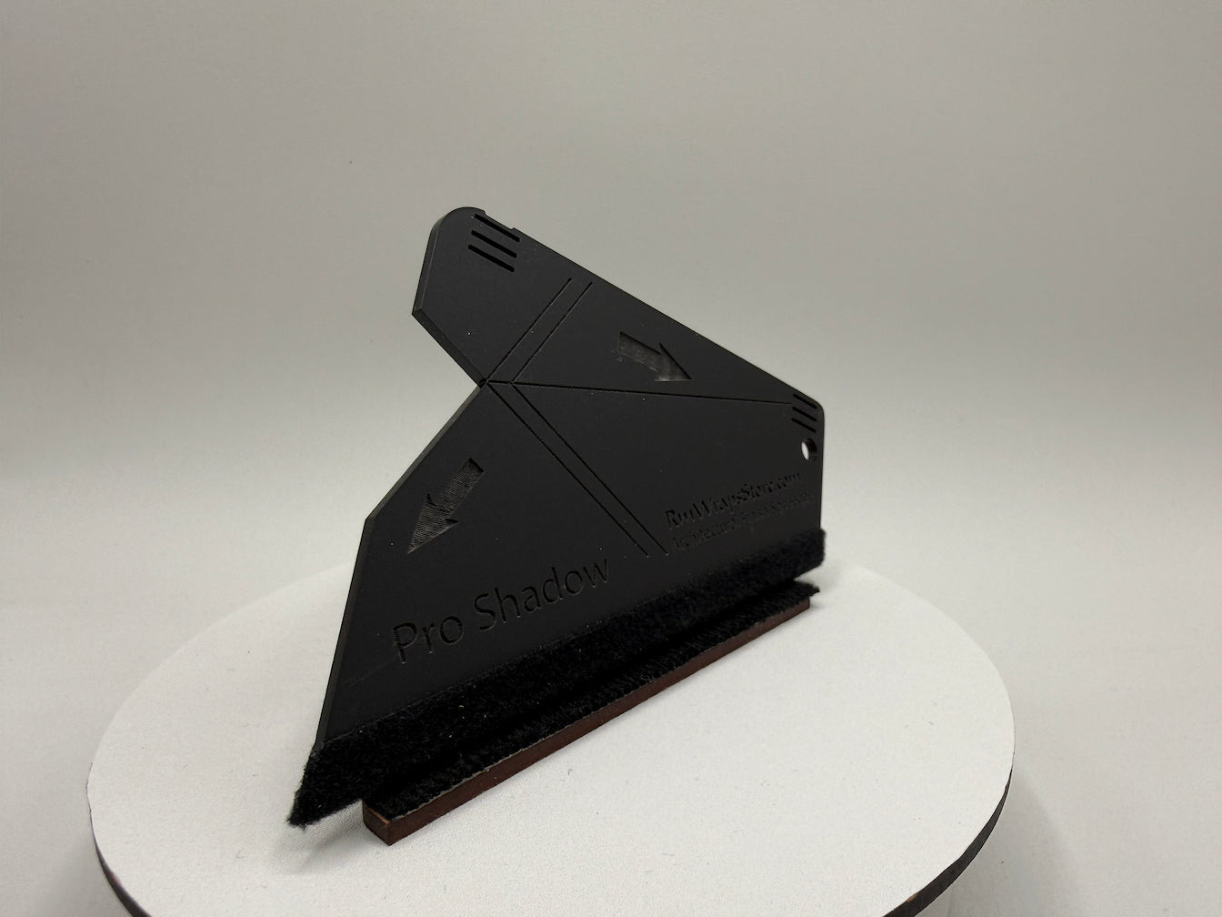 Black photography light modifier on a white stand with a gray background