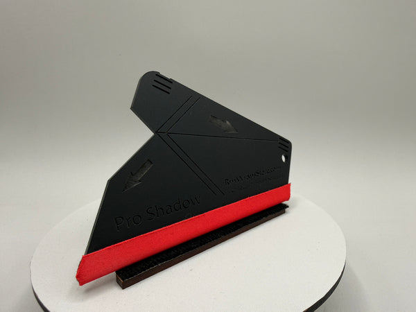 Black and red tool on a white stand with a gray background