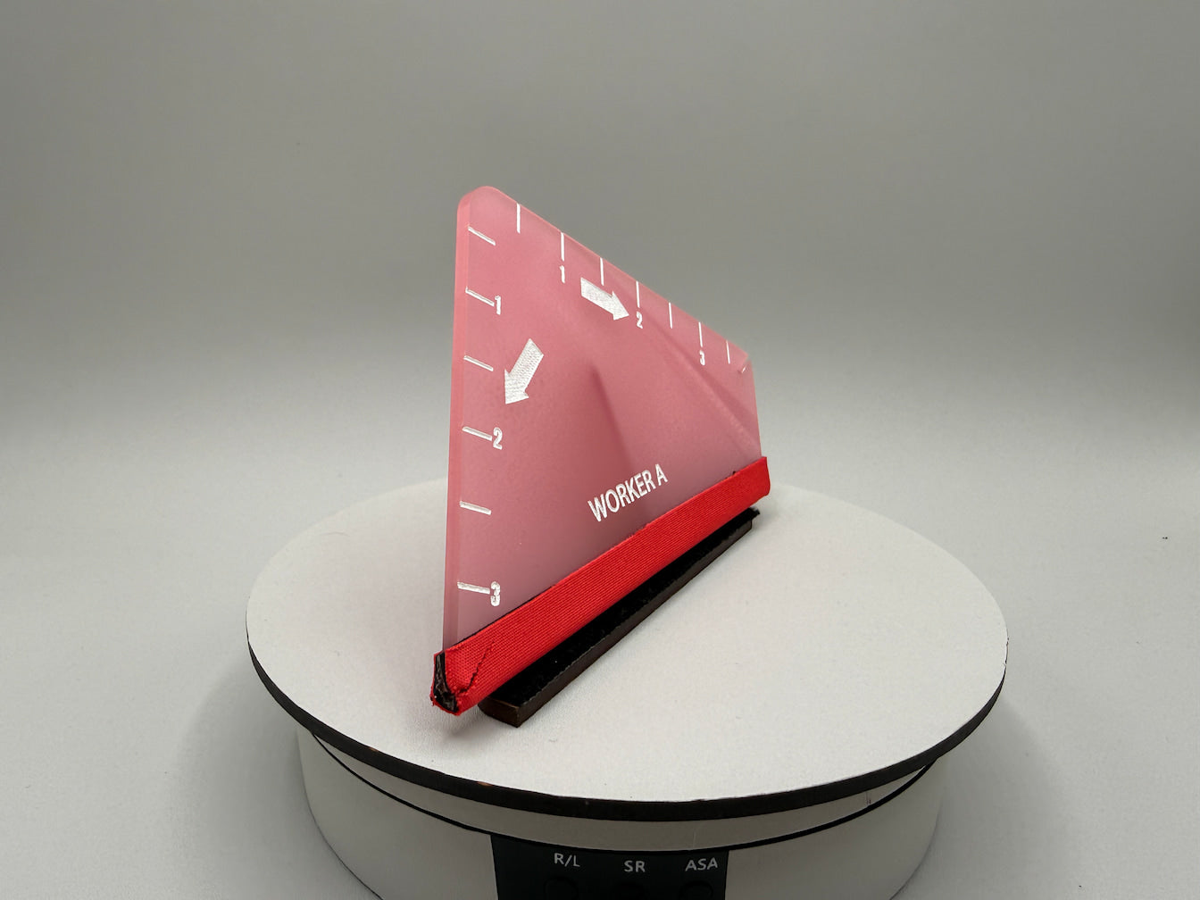 Red and black device on a white platform with a gray background