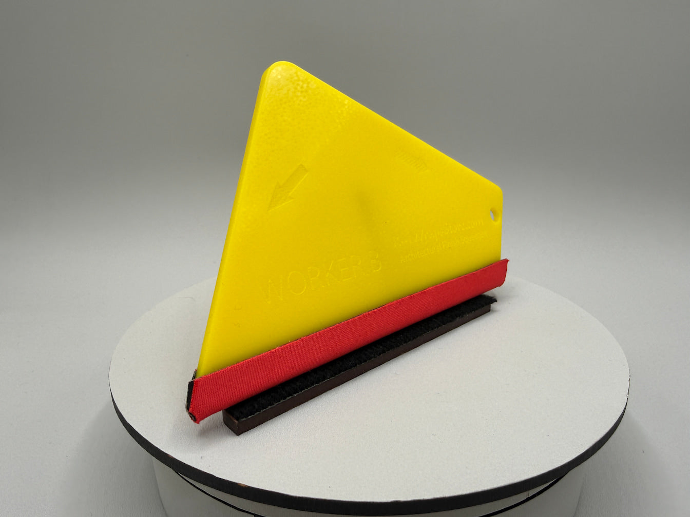 Yellow, red, and black triangular object on a gray background