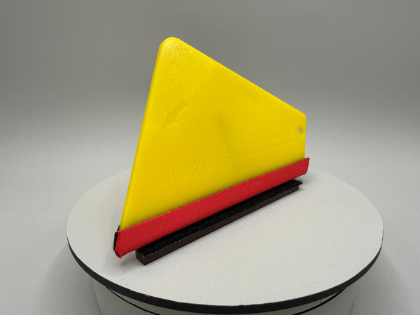Yellow, red, and black triangular object on a gray background