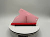 Pink and red object on a white platform with a gray background