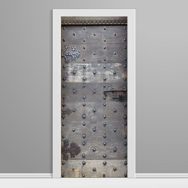 Decorative metal door with rivets on a gray background
