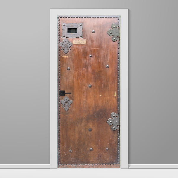 Wooden door with metal decorations on a gray background