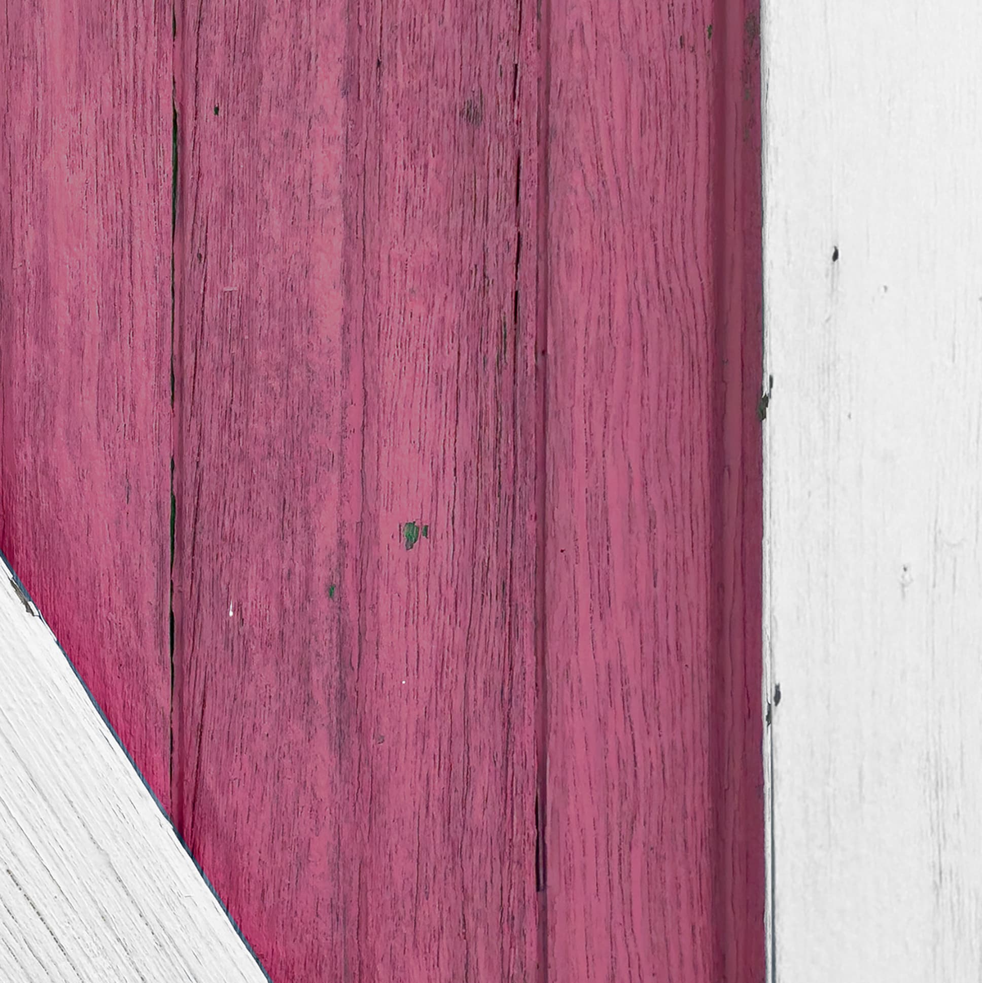 Close-up of a wooden surface with pinkish-brown planks and white edges.