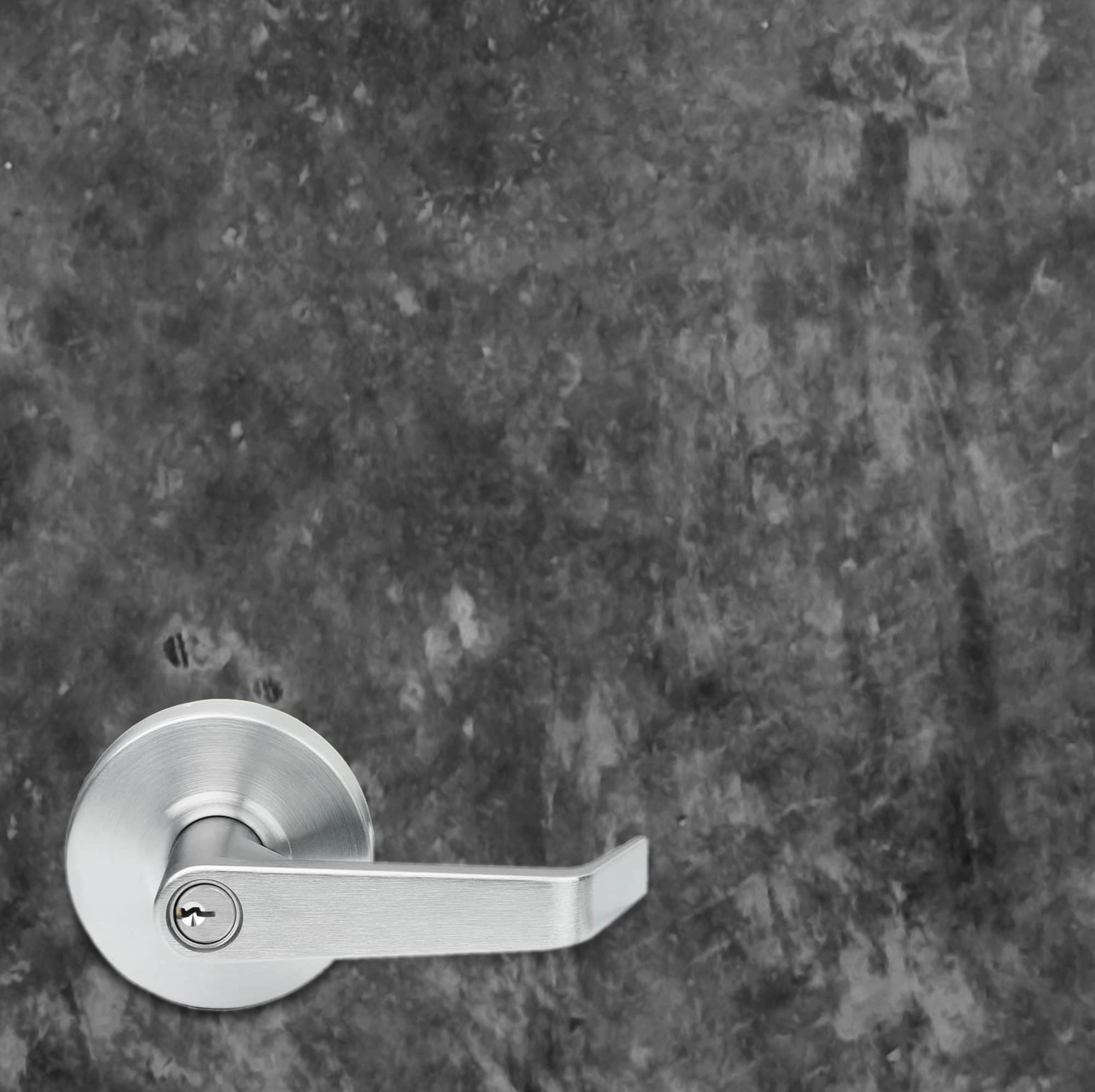 Silver door handle on a textured gray wall